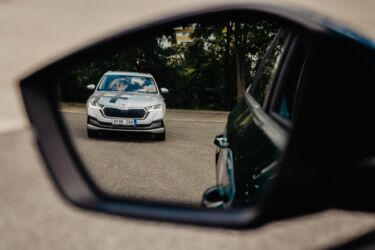 Kolemjedoucí auto v levé polovině zrcátka.